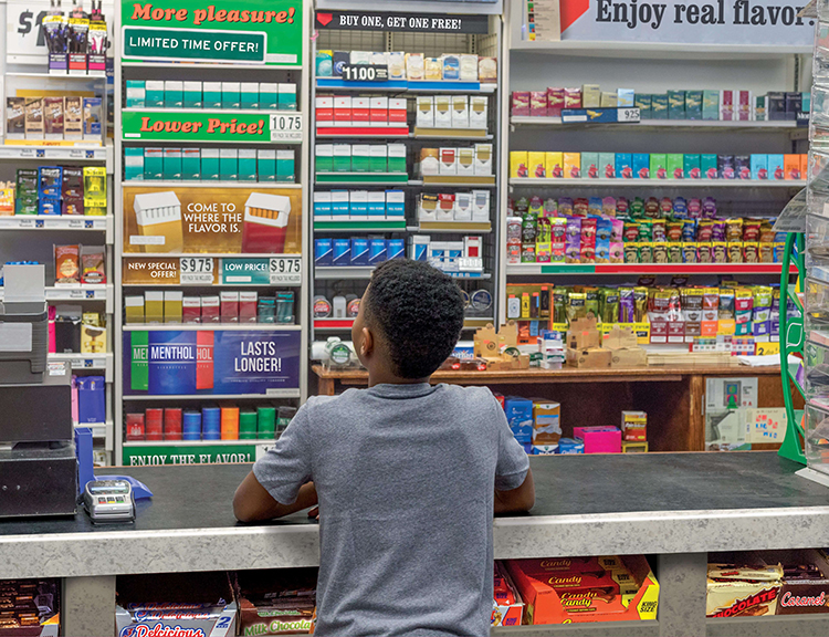 Boy at store counter looking at tobacco products